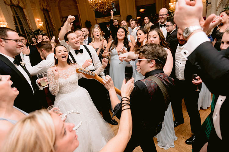 The guitarist of the Boston Wedding Band is surrounded by wedding guests as he plays a solo in the middle of dance floor