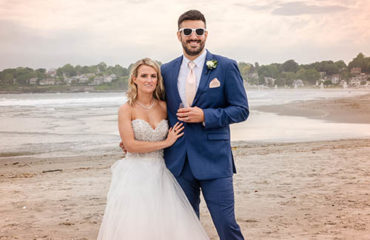 A newly married couple posing for a photo at Newport's first Beach