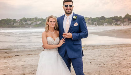 A newly married couple posing for a photo at Newport's first Beach