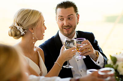 The bride and groom  hold their toast glasses.