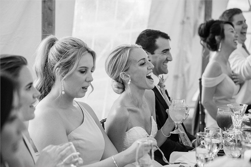The bride laughs at the best man's toast.