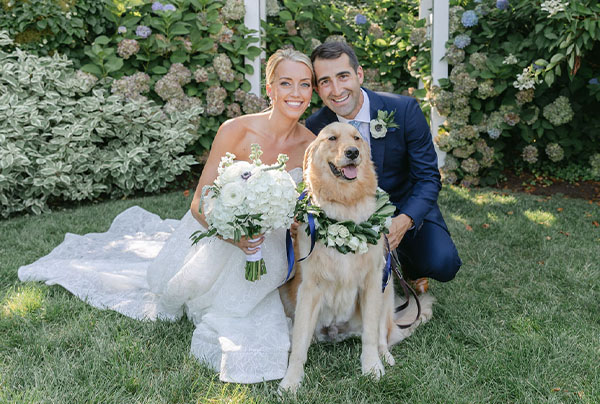 Erin and Adam pose with their dog for a wedding photo