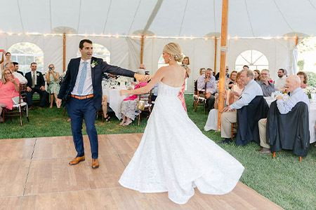 A bride and groom sharing their first dance under the tent at The Dennis Inn in Dennis, Massachusetts.