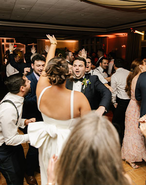 A bride and groom dancing with their friends as Boston Premier performs their favorite song.