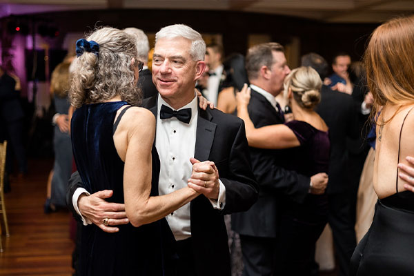 A couple dancing to a slow song at a wedding held at the state room.